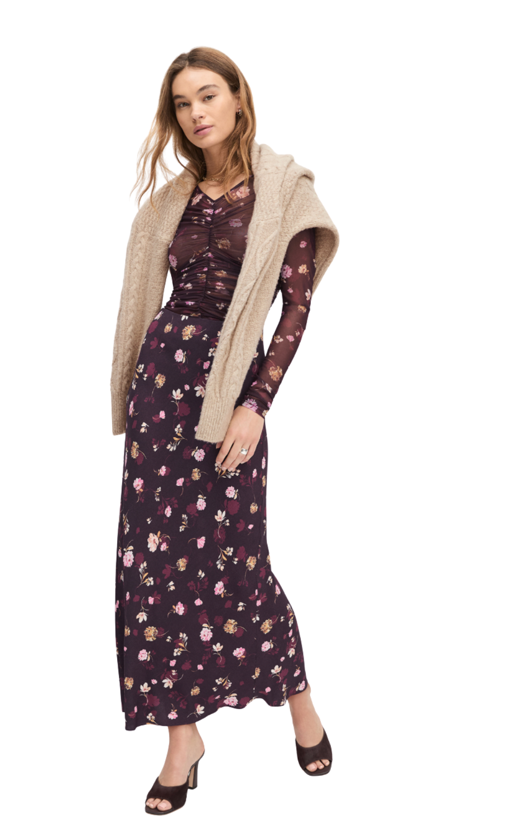 Woman wearing a floral shirt and skirt with a beige cardigan on a white background