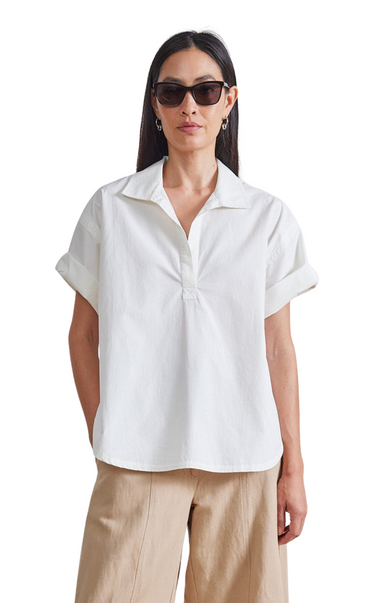 Apiece Apart Easy Pop-Over Henley. White short sleeve. Open neckline, straight silhouette, shirttail hem, side seam slits, short sleeves that can be cuffed