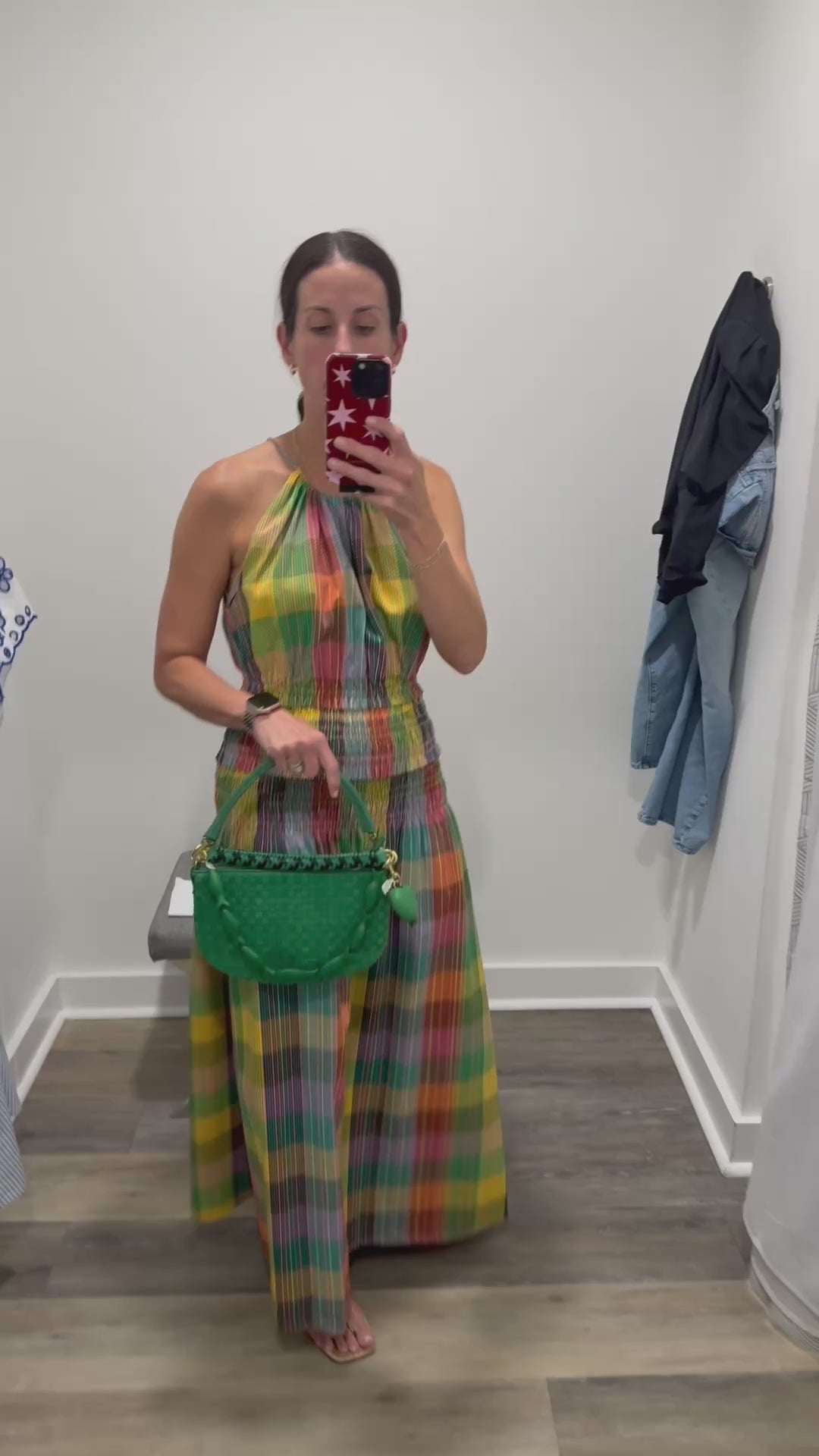woman in plaid colorful dress holding a green bag
