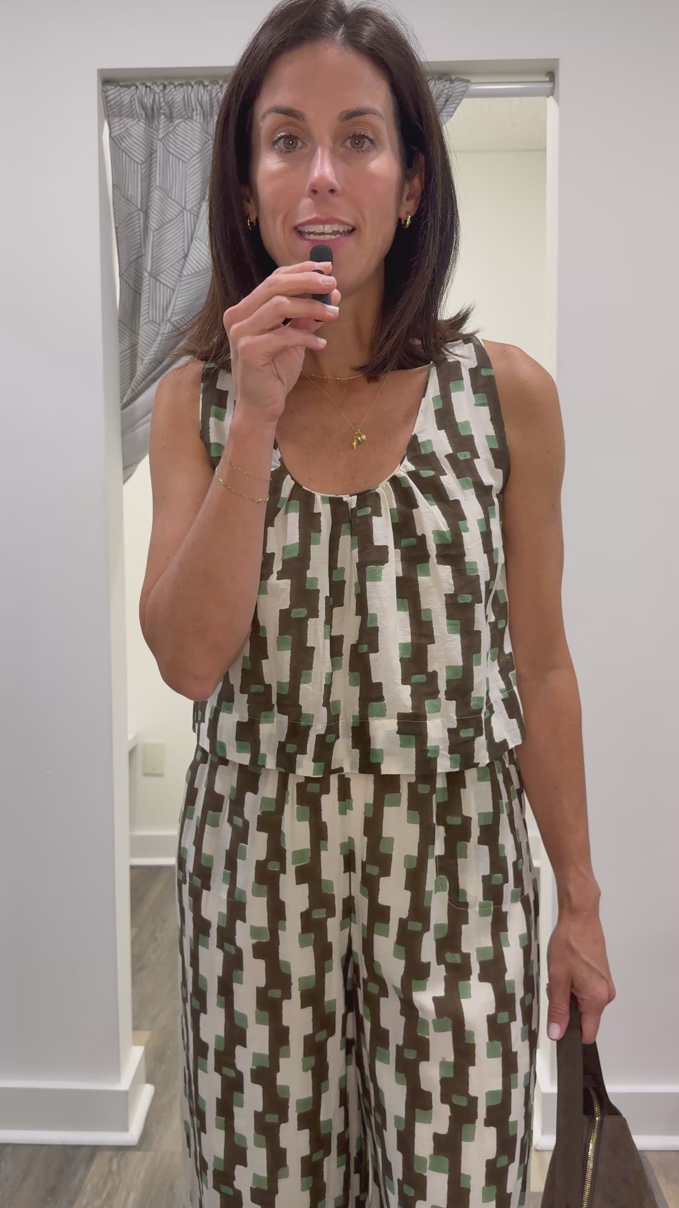 Woman in video discussing the details of the mirth green, cream and brown abstract print tank and matching pants.